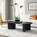 Louie oval black wood coffee table with curved panel slab legs styled in a modern living room