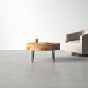 Keith round natural wood storage coffee table with black hairpin legs styled in a room