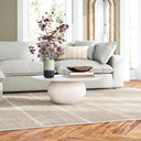 Nixon round white wash wood coffee table with a spherical ball pedestal base styled in a bright living room