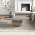 Chaim round light wood coffee table with spherical pedestal sphere base in a cozy living room