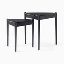 Lewis Tripod Nesting Side Table in black shown individually against a white background, highlighting its rounded tabletop and slim legs.