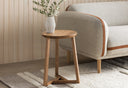 Martin light oak wood round end table styled next to a cream fabric sofa