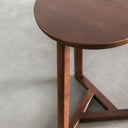 Macro view of Martin table edge showing dark brown wood grain texture and tripod leg joint