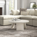 Landyn round white wash wood coffee table with intersecting panel legs styled in a living room