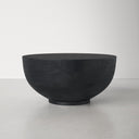 Finnley round black wood drum coffee table side studio view showcasing textured bowl base
