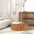 Sincere round wood drum coffee table with vertical fluted panel base styled in a living room