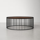 Zain round wood drum coffee table side studio view showcasing black slatted cage base