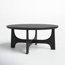 Skyler round black wood coffee table low-angle studio view highlighting architectural cross arched base