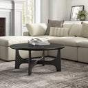 Skyler round black wood coffee table with cross arched pedestal base styled in a living room