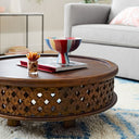 Chandler round carved wood coffee table close up lifestyle view styled with a colorful striped bowl