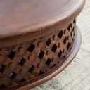 Close up angle view of Chandler coffee table showing carved lattice fretwork and dark wood rim