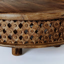 Close up straight view of Chandler natural carved coffee table showcasing geometric lattice details