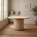 Casey 4 Seater Dining Table with a round light wood tabletop and fluted cylindrical pedestal base in a bright dining room.
