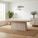 Langston Dining Table in a light whitewashed wood finish styled in a contemporary dining room with plants, neutral furnishings, and a textured rug.