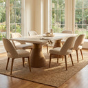 Skyler Solid Wood 8 Seater Dining Table in natural finish displayed in a spacious dining area with eight upholstered chairs and large windows.