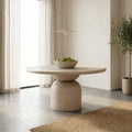 Tomas Round 6 Seater Dining Table with a light natural wood finish and sculptural pedestal base in a bright modern dining space.