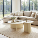 Aidan Cross Legs End Table duo arranged on a neutral area rug beside a beige sectional and decorative vase.