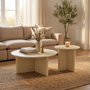 Aidan Cross Legs End Table set beside a cream sofa, featuring fluted bases and smooth round tabletops.