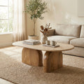 Alvin modern travertine marble oval coffee table with natural wood block legs in a living room