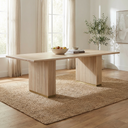 Tripp 6 Seater Dining Table in a bright dining room, featuring a light wood rectangular tabletop and fluted pedestal legs with brass-tone base trim.