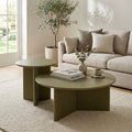 Aidan Cross Legs End Table in a warm neutral living room beside a cream sofa and round coffee table.