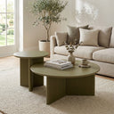 Aidan Cross Legs End Table in a warm neutral living room beside a cream sofa and round coffee table.