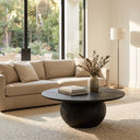 Nixon round black charcoal wood coffee table with a spherical ball pedestal base styled in a modern living room