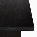 Medium brown Nixon Rosa Plank Dining Table shown in a studio setting with its long rectangular tabletop and two panel supports.