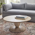 Leandro round natural wood coffee table with a stacked goblet pedestal base styled in a living room