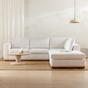 Leandro round natural wood coffee table styled in an airy living room with a large white sectional sofa